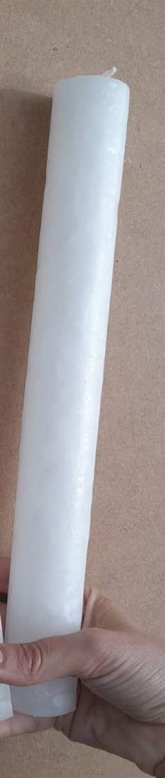 Vela cilíndrica branca segurada por uma mão