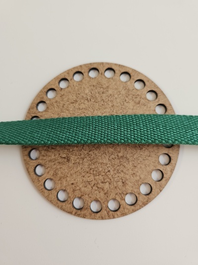 Cartão redondo de papelão com 24 furos ao redor e fita verde texturada