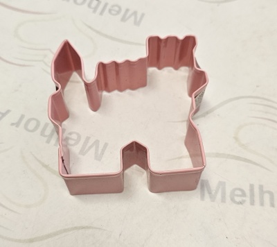 Cortador de bolachas rosa em forma de castelo sobre superfície branca