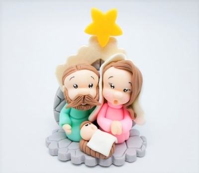 Figurinha decorativa do presépio com três personagens e estrela amarela