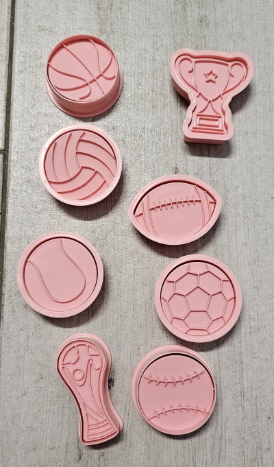 Moldes de silicone rosa com desenhos de bolas desportivas e troféu