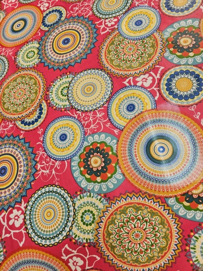 Tecido com padrão de mandalas coloridas em fundo vermelho