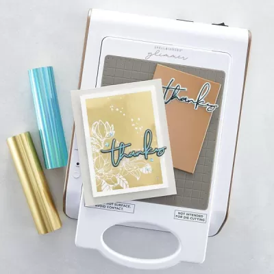 Máquina SPELLBINDERS glimmer com cartas decorativas e rolos metálicos azul e dourado