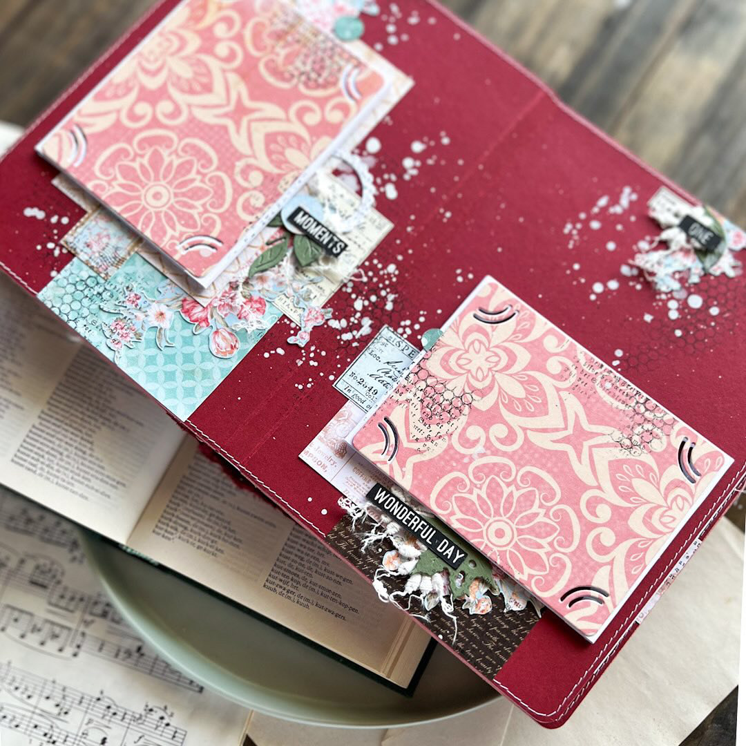 Reserva Workshop Presencial | Olena Khyzníak | Mel's Scrap Livro artesanal aberto com páginas coloridas e etiquetas decorativas