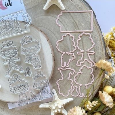 Conjunto de carimbos com personagens e moldes cortantes em metal rosé sobre madeira redonda com flores e estrelas-do-mar