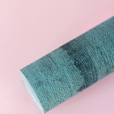 Rolo de toalha azul com textura em fundo rosa.