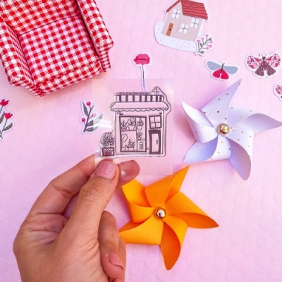 Autocolante de montra de loja com flores e flores e cataventos de papel sobre fundo rosa