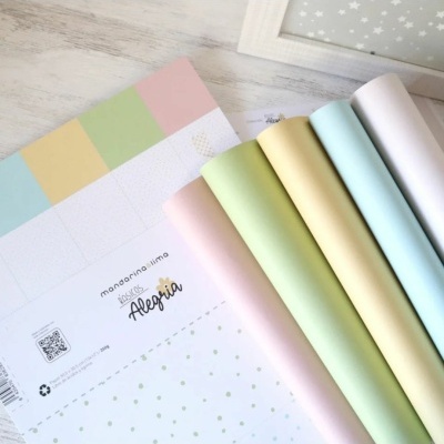 rolos de papel decorativo em cores pastel com etiqueta e caderno colorido