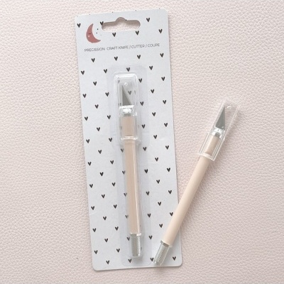 Faca de precisão para trabalhos manuais com cabo bege e lâmina metálica em embalagem decorada