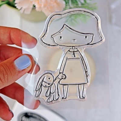 Carimbo transparente com desenho de menina de cabelo curto a segurar um coelho