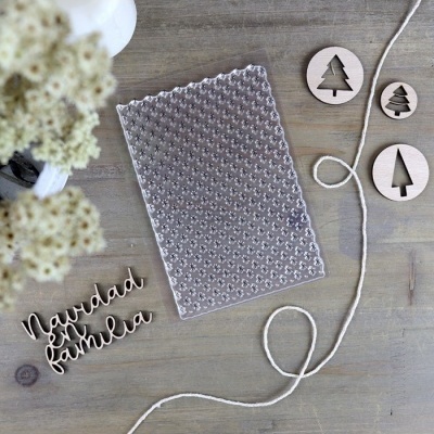 Placa de silicone transparente com padrão e recortes de madeira com temas natalícios numa mesa