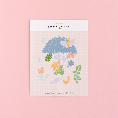 Cartão decorativo com guarda-chuva azul, flores e folhas coloridas sobre fundo rosa.