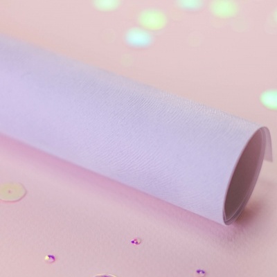 Papel branco texturizado e confetes brilhantes sobre fundo rosa