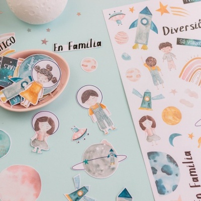 Autocolantes coloridos com temas de espaço e família em superfície azul clara