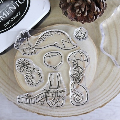 Carimbos de silicone com desenhos de animais e natureza sobre base de madeira.