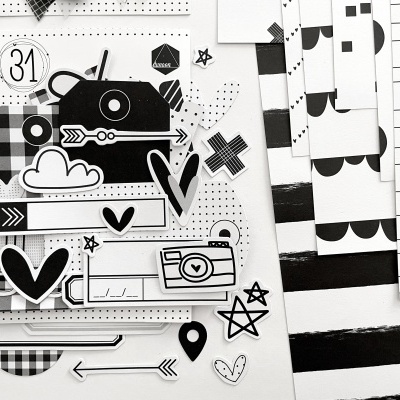 Autocolantes decorativos em preto e branco com formas variadas sobre folha branca