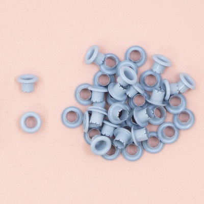 Ilhós de plástico azul claro sobre superfície rosa