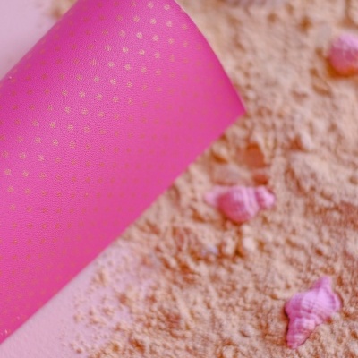 Tapete de yoga rosa com pontos dourados sobre areia com conchas pequenas