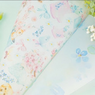 Tecidos estampados com padrões florais em tons pastel e flores naturais ao lado