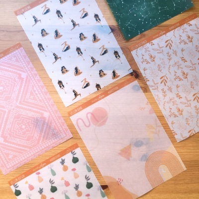 Papéis decorativos variados com padrões geométricos, figuras e constelações