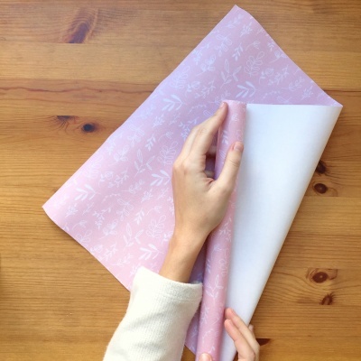 Papel de embrulho cor-de-rosa com padrão branco de folhas e flores