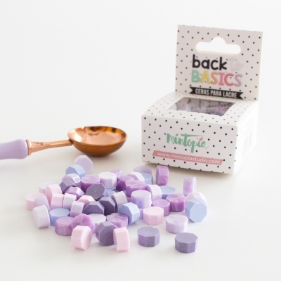 Pequenos lacres coloridos lilás, roxo e rosa com caixa branca e colher pequena