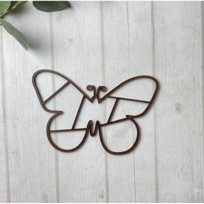 Suporte metálico castanho em forma de borboleta sobre madeira clara