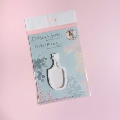 Embalagem de Shaker Frasco da marca El Altillo de los duendes com fundo azul e rosa e detalhes florais