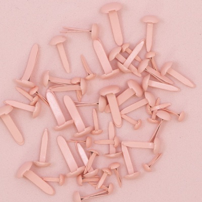 Alfinetes de plástico rosa com cabeça redonda sobre fundo rosa