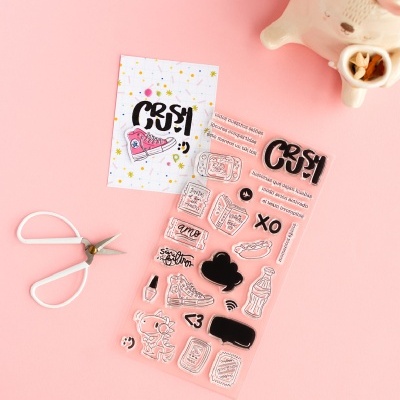 Conjunto de carimbos variados sobre fundo rosa com uma tesoura e um jarro branco