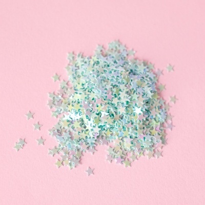 Estrelas holográficas pequenas sobre fundo rosa