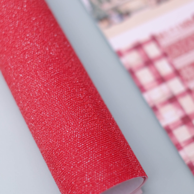 Rolo de papel vermelho texturizado com brilho ao lado de calendário