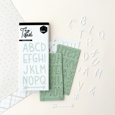 Moldes de letras alfabeto com letras cortadas em plástico branco ao lado da embalagem.