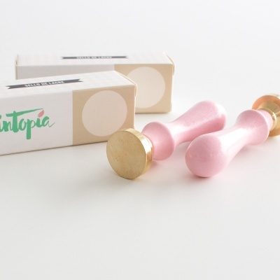 Dois carimbos de lacre cor de rosa com bases douradas e caixas brancas