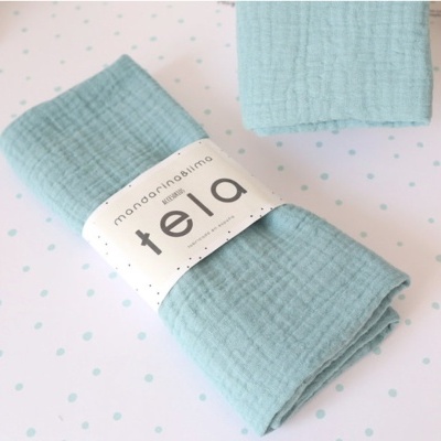 Toalha azul clara com etiqueta branca 'manzanita slima tela' sobre fundo branco com pontos azuis