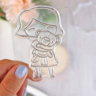 Selo transparente com desenho de menina a abraçar ursinho