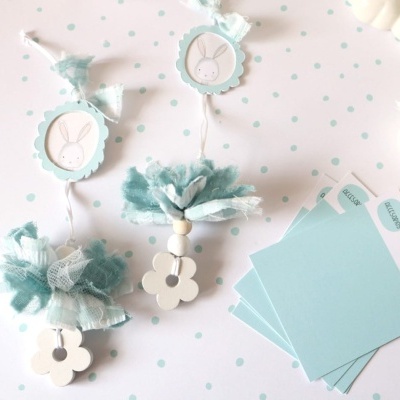 Marcadores decorativos com flores de madeira e pompons em tecido azul e branco