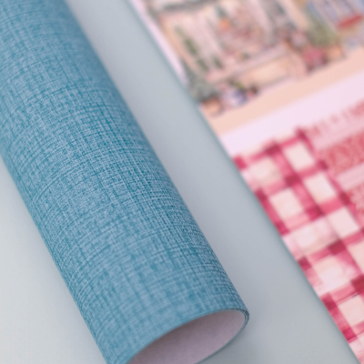 Papel de presente azul enrolado com padrão texturizado e papel decorativo xadrez vermelho e branco com ilustrações