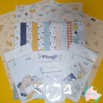 Conjuntos de papéis decorativos e recortes de scrapbook da marca Paperie com padrões florais, geométricos e temáticos, dispostos sobre fundo amarelo