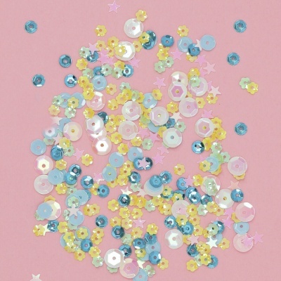 Lantejoulas coloridas em formas de flores e estrelas num fundo rosa