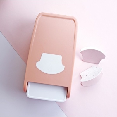 Dispositivo retangular cor de rosa e branco com peças removíveis em superfície rosa claro e roxo