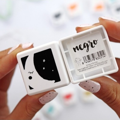 Mini estojo de tinta preta com tampa ilustrada e rótulo negro