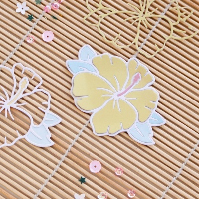 Adesivos de flor hibisco amarelo e azul sobre tapete de bambu com lantejoulas