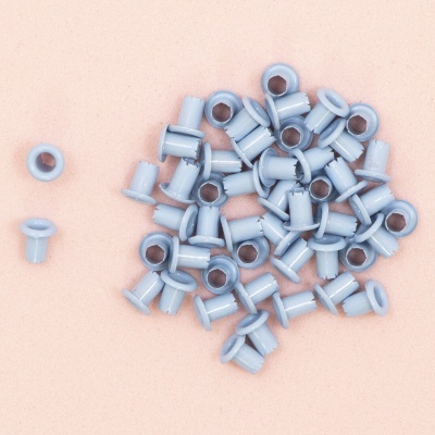 Ilhóses de plástico cinza claro sobre fundo cor de rosa