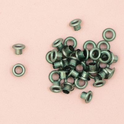 Conjunto de ilhós de metal prateado sobre fundo rosa