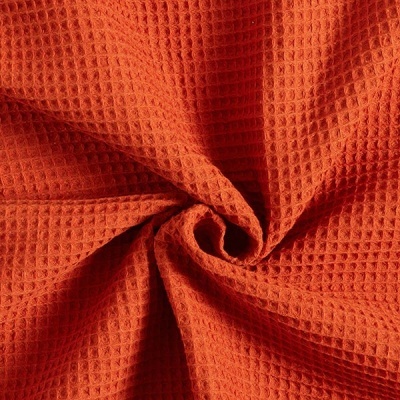 tecido laranja com textura tipo waffle dobrado em espiral