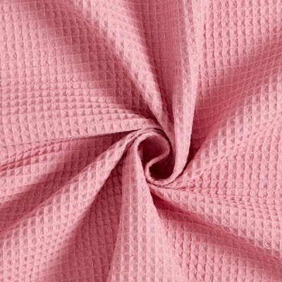 Tecido rosa textura waffle em close-up enrolado no centro