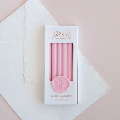 Conjunto de cinco velas rosas em embalagem branca com selo rosa e texto