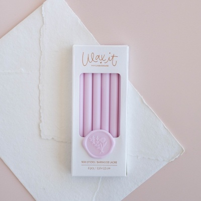 Caixa de velas cor de rosa clara com selo redondo, sobre papel branco