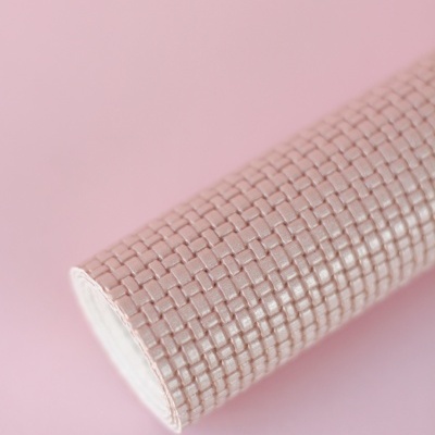 Tubo cilíndrico com revestimento quadriculado rosa claro sobre fundo rosa